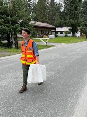 Spill response staff member walking with oil absorbent pads.